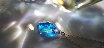 ラフォルム ガラスジュエリー ガラスアクセサリー 水鏡の結晶 水の煌く表情をそのまま氷のかけらの中に閉じ込めたような、世界にひとつの美しいペンダントが完成いたしました。透明感のあるターコイズブルー系の色味の中にランダムな煌きが美しい逸品です。