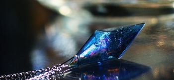 ラフォルム ガラスジュエリー ガラスアクセサリー Dreamblue ～ Resonance macrocosm ～ 透明感のある濃い目のアクアマリンブルーの八面体の内部には、光のあたり方や見る角度によって、無限の表情を見せてくれる神秘的なレインボ…