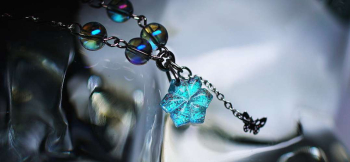 ラフォルム ガラスジュエリー ガラスアクセサリー Snow princess ～ Charming bracelet ～ 雪の花を思わせる青緑色のガラストップに、虹色のビーズや蝶、花のチャームを組み合わせました。花びらへ施した細かな彫刻が光を反射し…