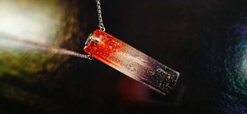 ラフォルム ガラスジュエリー ガラスアクセサリー Pillar of Sparkle 夕焼けから夜へ移り変わる空を、一本の光の柱のような直方体へ閉じ込めました。上部の明るいオレンジから無色透明を経て、下部の深いパープルへ続くグラデーションに、ゴール…