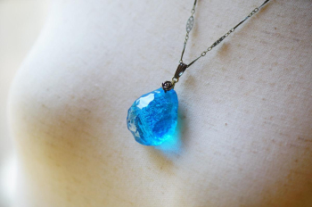 水の誕生 ～ 時雫の結晶 ～ 光がペンダントの内部に浸透し、青い輝きがふわっと広がる瞬間を捉えた美しい一枚。水の結晶が動きとともにその力強さを感じさせ、心に残る印象を与えます。 ラフォルム ガラスジュエリー ガラスアクセサリー